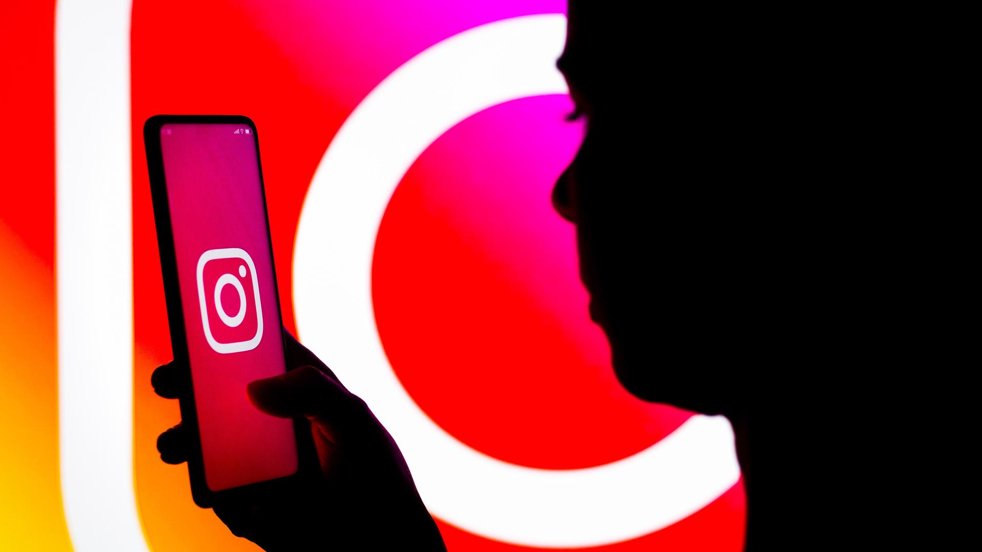 Eine Frau öffnet auf ihrem Handy die Instagram-App