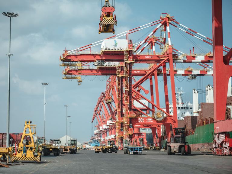 Blick auf rote Krananlagen des Doraleh Multi-Purpose Port in Dschibuti, der 2017 eröffnet worden ist. Gebaut wurde das Terminal von China.