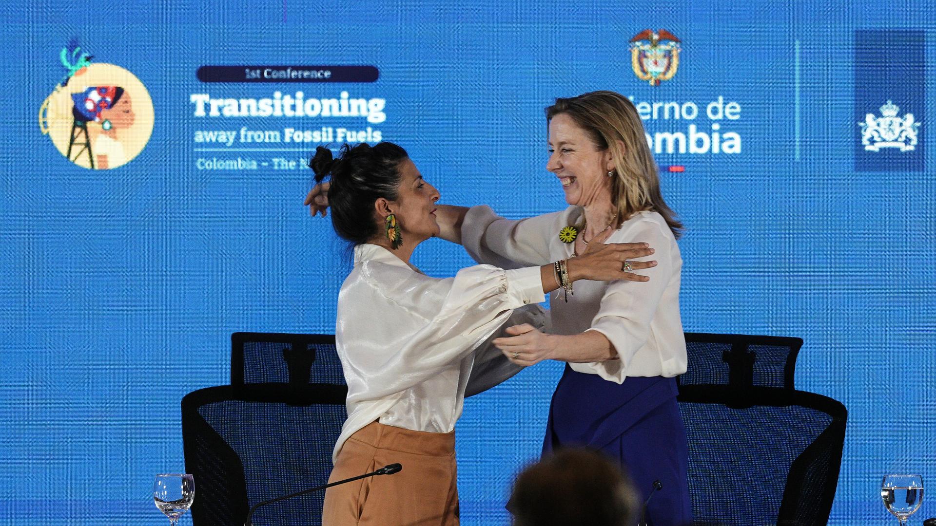 Zwei Frauen umarmen sich auf einer Bühne.