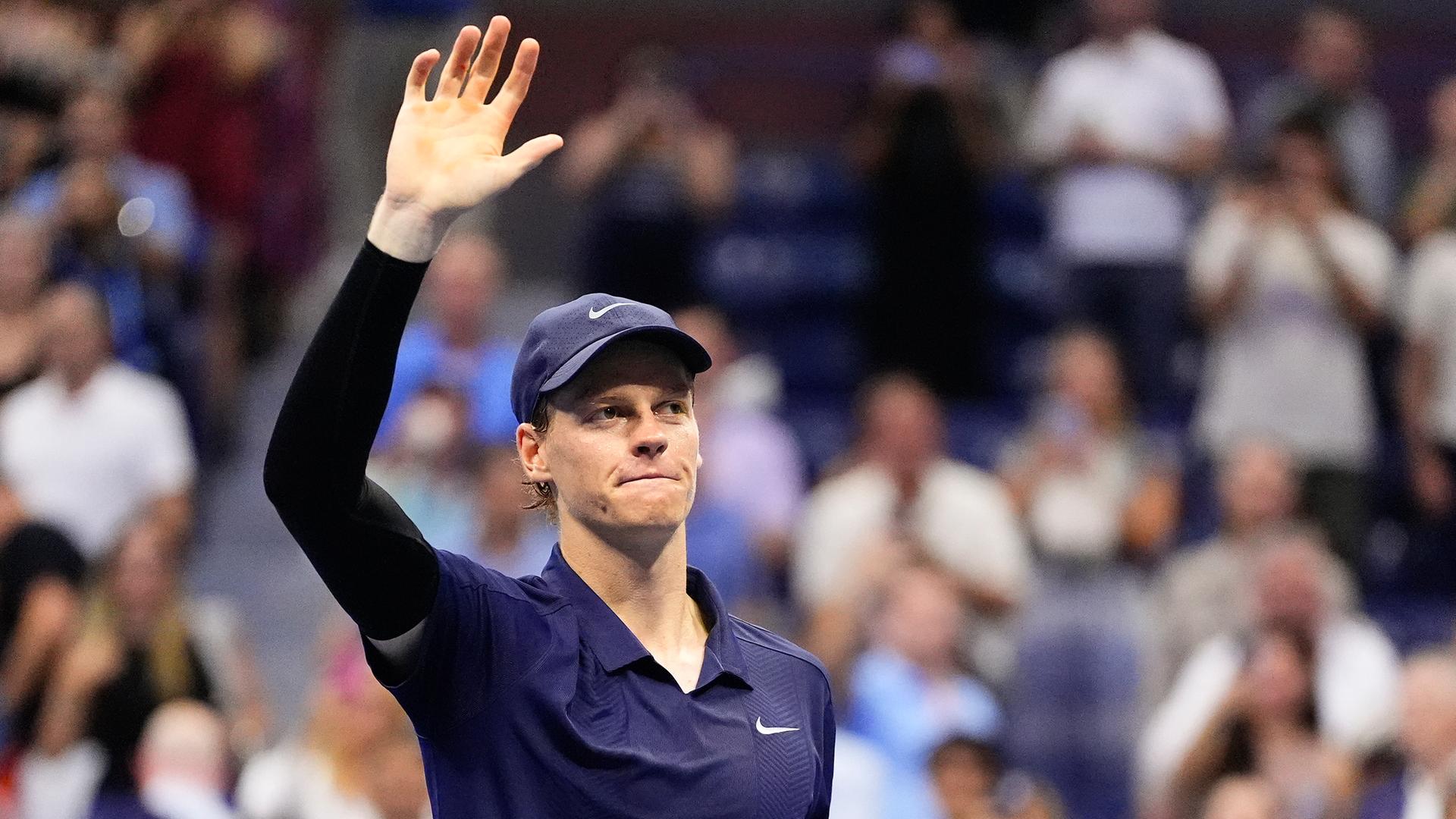 Jannik Sinner steht bei den US Open in New York auf dem Platz. Er grüßt nach seinem Sieg ins Publikum.