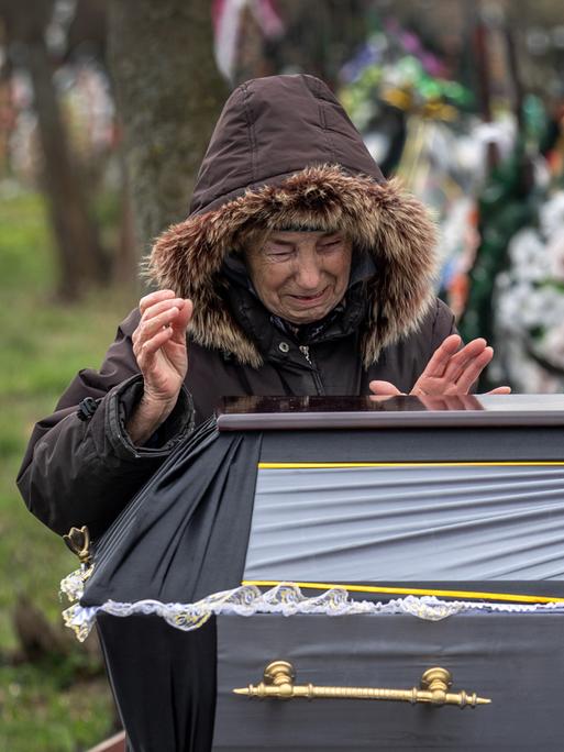Valentyna Nechyporenko, 77, weint am Grab ihres Sohnes Ruslan Nechyporenko, 47, während dessen Beerdigung am 18. April 2022 in Butscha. Seine Leiche wurde in Butscha gefunden, nachdem sich die russischen Soldaten Wochen zuvor zurückgezogen hatten. Sie ist eine von mindestens 700 ermordeten Zivilisten, die den Behörden zufolge in Städten rund um Kiew gefunden wurden. 