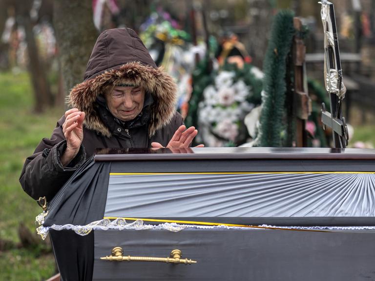 Valentyna Nechyporenko, 77, weint am Grab ihres Sohnes Ruslan Nechyporenko, 47, während dessen Beerdigung am 18. April 2022 in Butscha. Seine Leiche wurde in Butscha gefunden, nachdem sich die russischen Soldaten Wochen zuvor zurückgezogen hatten. Sie ist eine von mindestens 700 ermordeten Zivilisten, die den Behörden zufolge in Städten rund um Kiew gefunden wurden. 