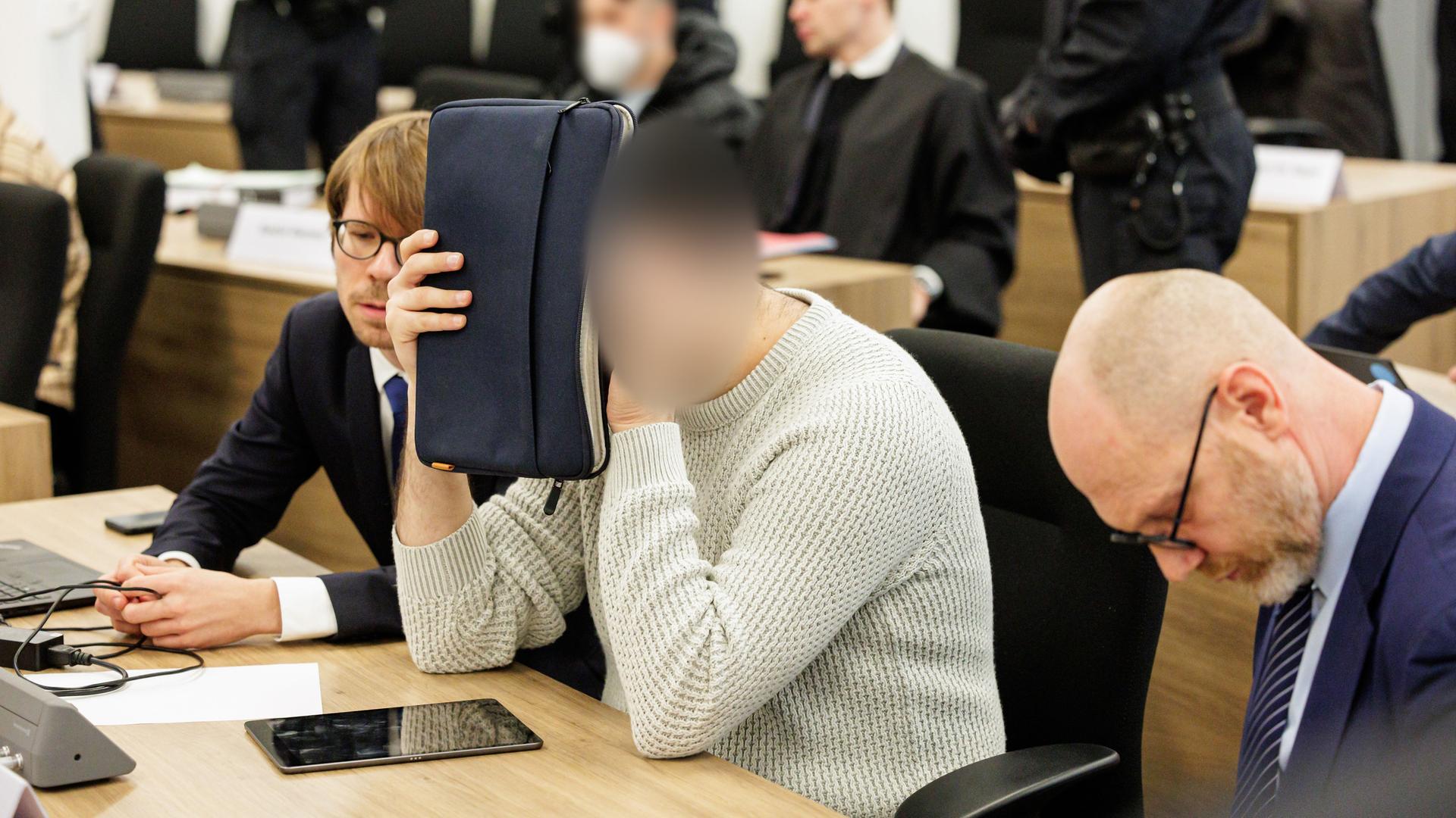 Dresden: Ein Angeklagter (M) bedeckt sein Gesicht  im Gerichtssaal des Oberlandesgerichts Dresden, bevor der Prozess um den Juwelenraub im Grünen Gewölbe des Dresdner Residenzschlosses im November 2019 beginnt. 