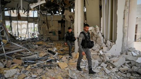 Das Foto zeigt zwei israelische Polizisten, die in der Stadt Petah Tikva ein von einer iranischen Rakete beschädigtes Gebäude inspizieren. 