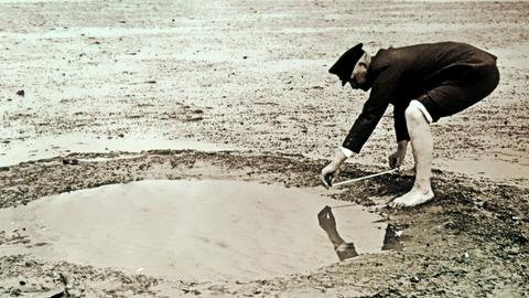 Das undatierte historische Foto zeigt den Landwirt und Hobby-Archäologen Andreas Busch bei der Vermessung von Brunnenresten im Rungholt-Watt. Rungholt wird in Sage und Dichtung als ein reicher Handelsort in Nordfriesland beschrieben. Die grosse Sturmflut von 1362 zerstörte die Siedlung und das Umland. 