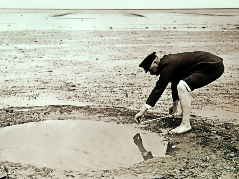 Das undatierte historische Foto zeigt den Landwirt und Hobby-Archäologen Andreas Busch bei der Vermessung von Brunnenresten im Rungholt-Watt. Rungholt wird in Sage und Dichtung als ein reicher Handelsort in Nordfriesland beschrieben. Die grosse Sturmflut von 1362 zerstörte die Siedlung und das Umland. 