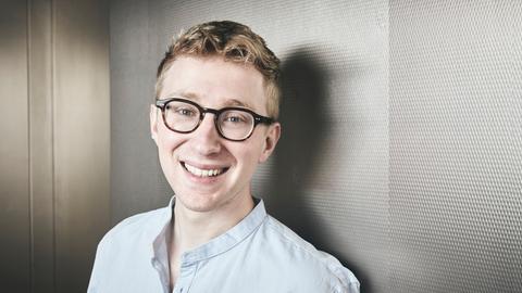 Auf dem Bild ist ein Mann zu sehen, der freundlich in die Kamera lächelt.