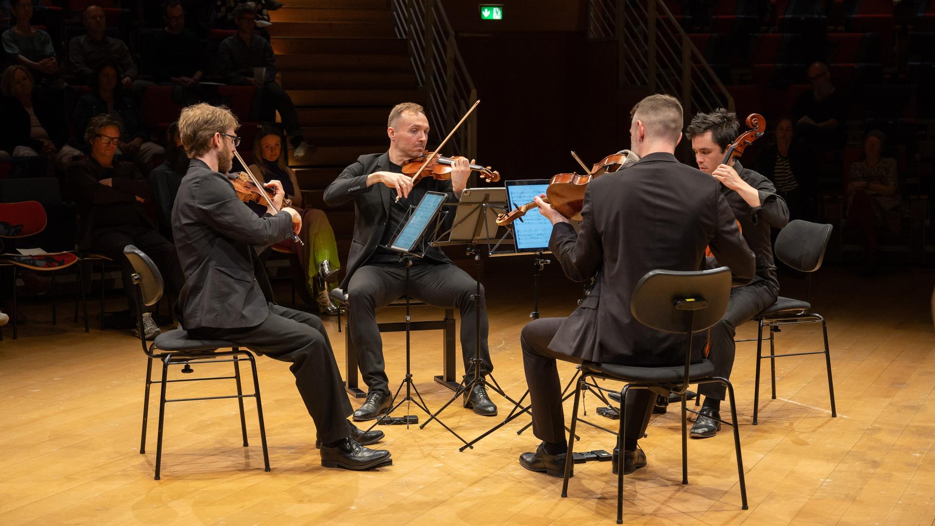 Ein Streichquartett spielt auf dem hellen Parkett des Boulez Saals Berlin Ein Streichquartett spielt auf dem hellen Parkett des Boulez Saals Berlin