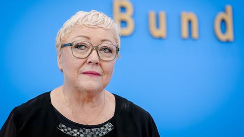 Das Bild zeigt Evelyn Zupke vor der blauen Wand der Bundespressekonferenz.