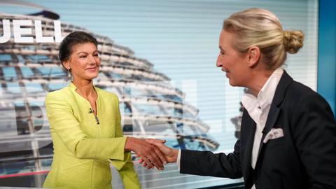 Alice Weidel und Sahra Wagenknecht reichen in einem TV-Studio einander die Hände 