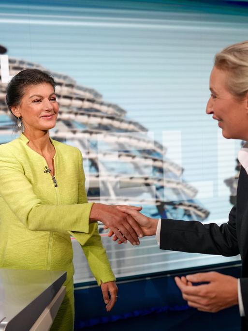 Alice Weidel und Sahra Wagenknecht reichen in einem TV-Studio einander die Hände Alice Weidel und Sahra Wagenknecht reichen in einem TV-Studio einander die Hände