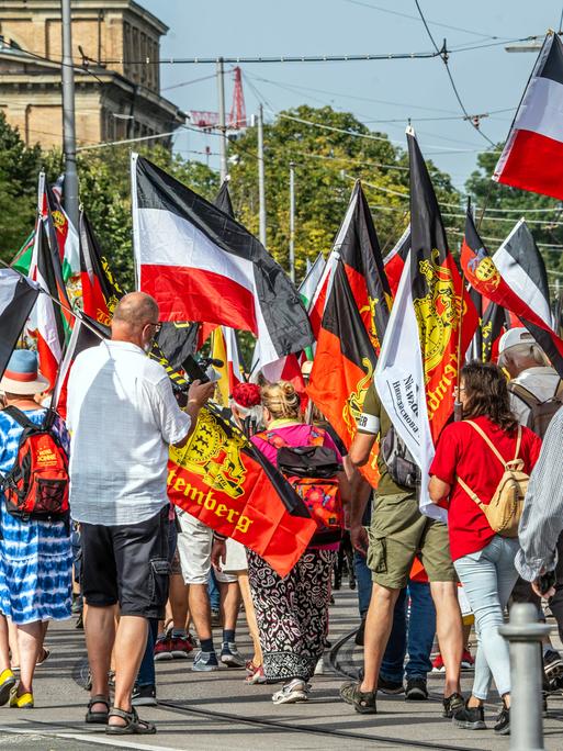 Reichsbürger-Treffen, Demonstrationszug, rot-weiße Flaggen.