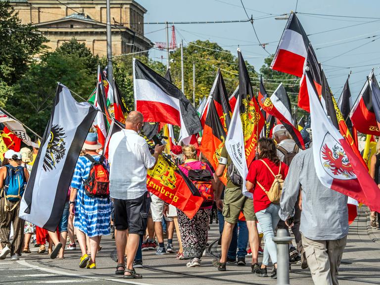 Reichsbürger-Treffen, Demonstrationszug, rot-weiße Flaggen.