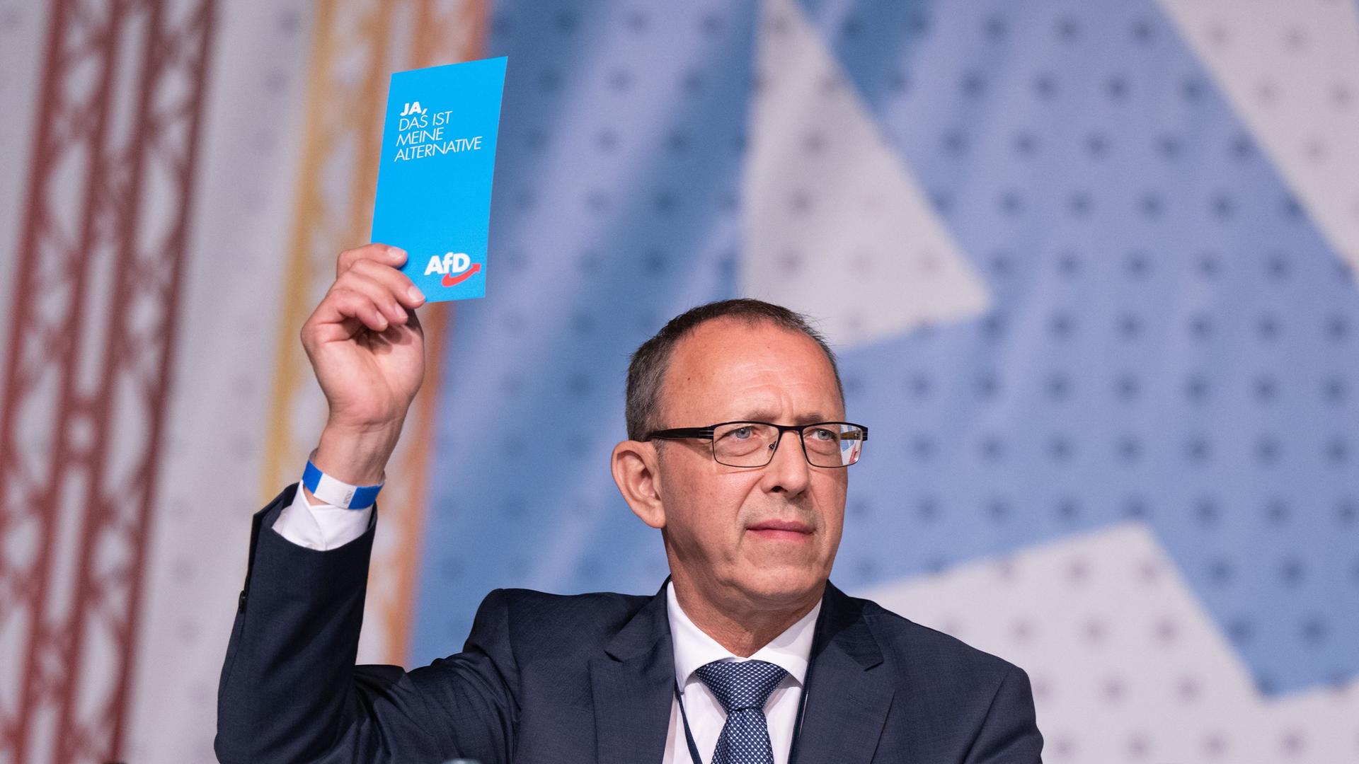 Jörg Urban, Vorsitzender der AfD in Sachsen, hält während des Landesparteitag seiner Partei im Messe- und Veranstaltungspark Löbau seine Stimmkarte in der Hand.