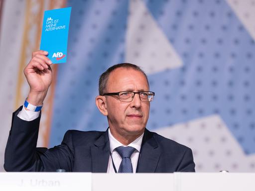 Jörg Urban, Vorsitzender der AfD in Sachsen, hält während des Landesparteitag seiner Partei im Messe- und Veranstaltungspark Löbau seine Stimmkarte in der Hand.