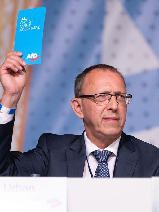 Jörg Urban, Vorsitzender der AfD in Sachsen, hält während des Landesparteitag seiner Partei im Messe- und Veranstaltungspark Löbau seine Stimmkarte in der Hand.