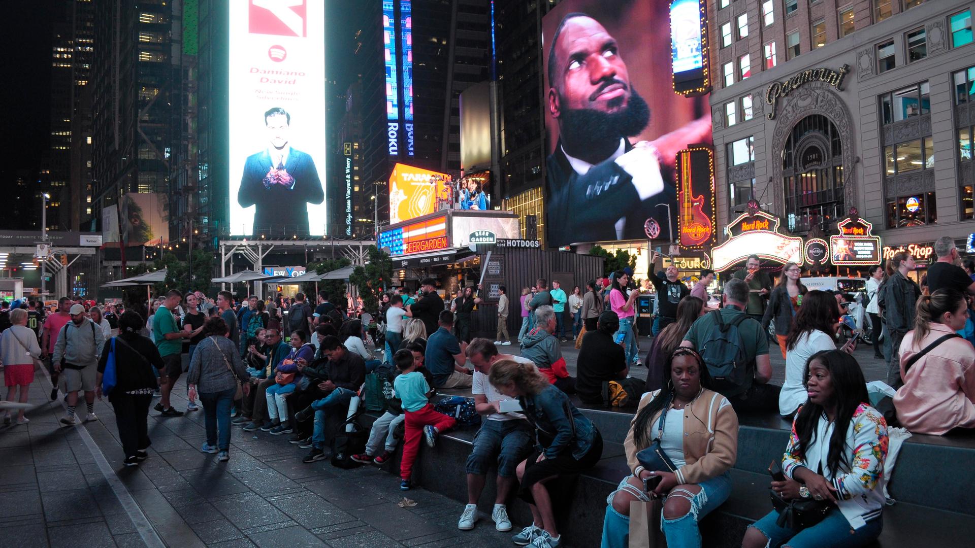 Menschen sitzen am New Yorker Times Square, 27.09.2024