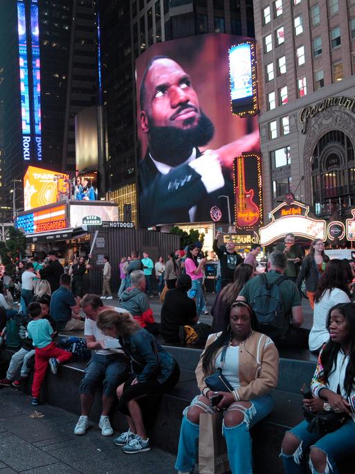 Menschen sitzen am New Yorker Times Square, 27.09.2024