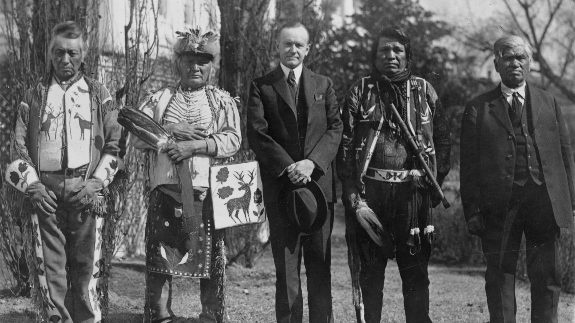 Historisches Schwarzweißfoto von Calvin Coolidge mit Native Americans der Osage Nations vor dem Weißen Haus.