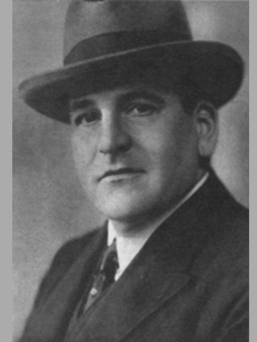 Hugo Bettauer im Anzug und mit Hut. Eine schwarz-weiß Fotografie.