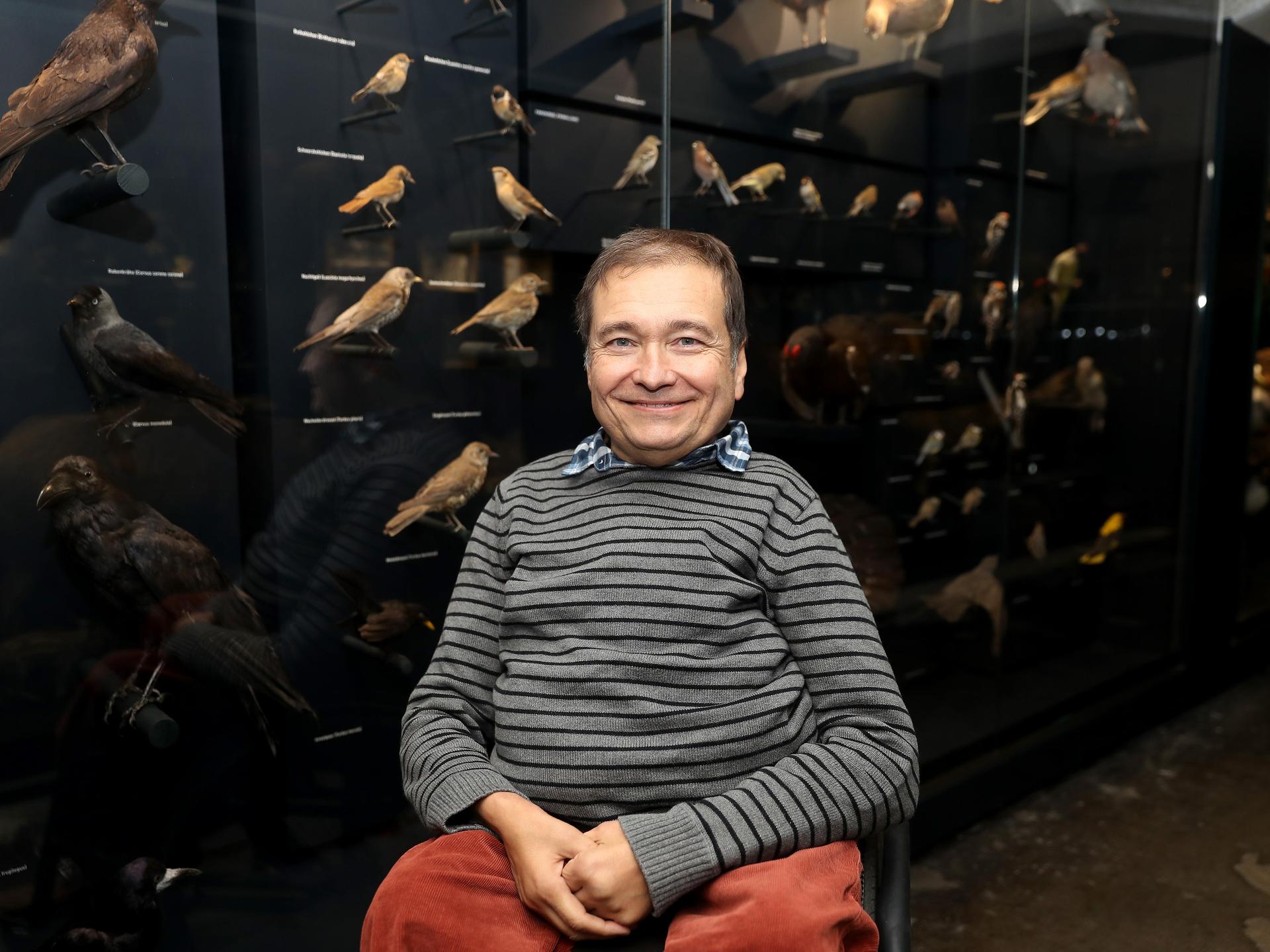 Onur Güntürkün, Professor für Biopsychologie sitzt in der Sonderausstellung Mensch und Tier im Rurhmuseum in Essen vor ausgestellten Vögeln. 