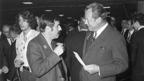 Ein Schwarz-Weiß-Foto zeigt Willy Brandt (rechts) und Günter Grass in der Akademie der Künste in Berlin im Gespräch. Beide tragen Anzug, Hemd und Krawatte. Ein Schwarz-Weiß-Foto zeigt Willy Brandt (rechts) und Günter Grass in der Akademie der Künste in Berlin im Gespräch. Beide tragen Anzug, Hemd und Krawatte.