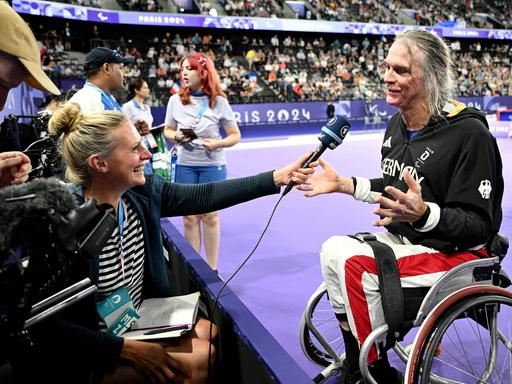 Thomas Wandschneider sitzt in seinem Rollstuhl vor einem Mikrofon beim Interview nach seinem 3.Platz im Badminton bei den Paralympics 2024 in Paris. 