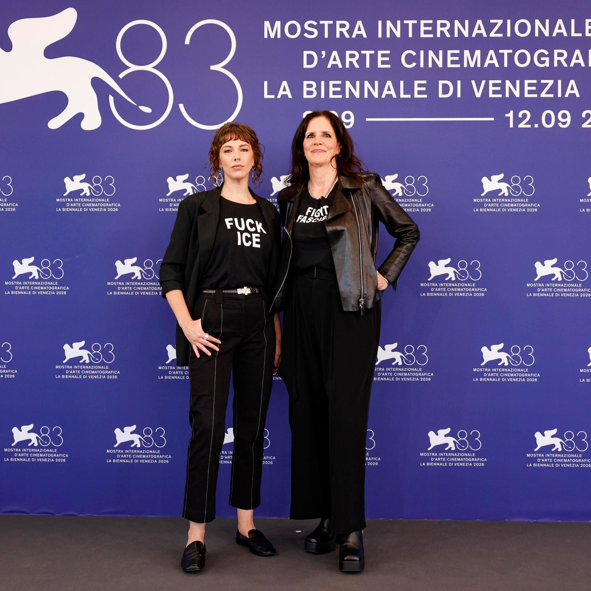 Die Regisseurin Laura Poitras und ihre Kollegin Rachel Lauren Mueller stehen in Venedig bei den Filmfestspielen vor einer blauen Wand mit Logos der Veranstaltung.
