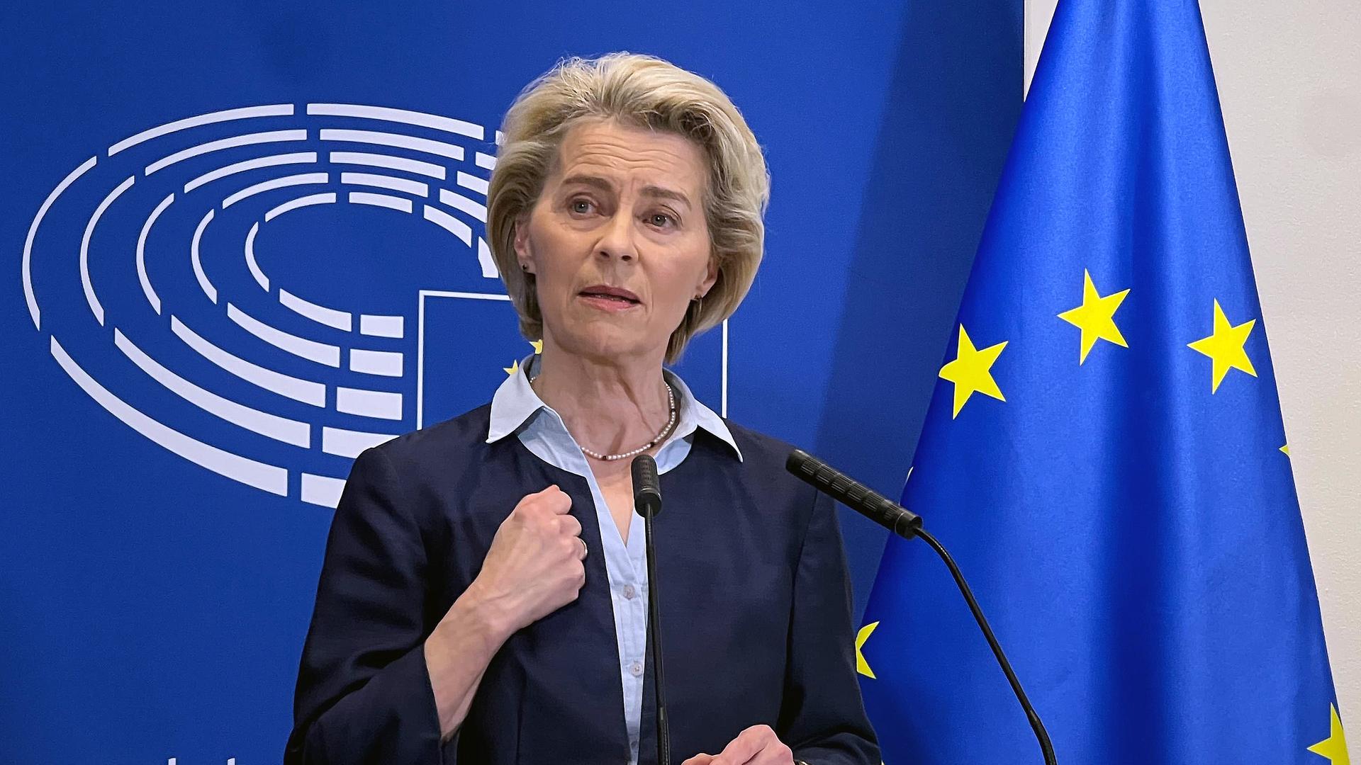 Ursula von der Leyen, Präsidentin der Europäischen Kommission, spricht bei einer Pressekonferenz im Europäischen Parlament. Hinter ihr das Logo des Europäischen Parlaments mit dem stilisierten Plenarsaal und daneben die EU-Flagge.  