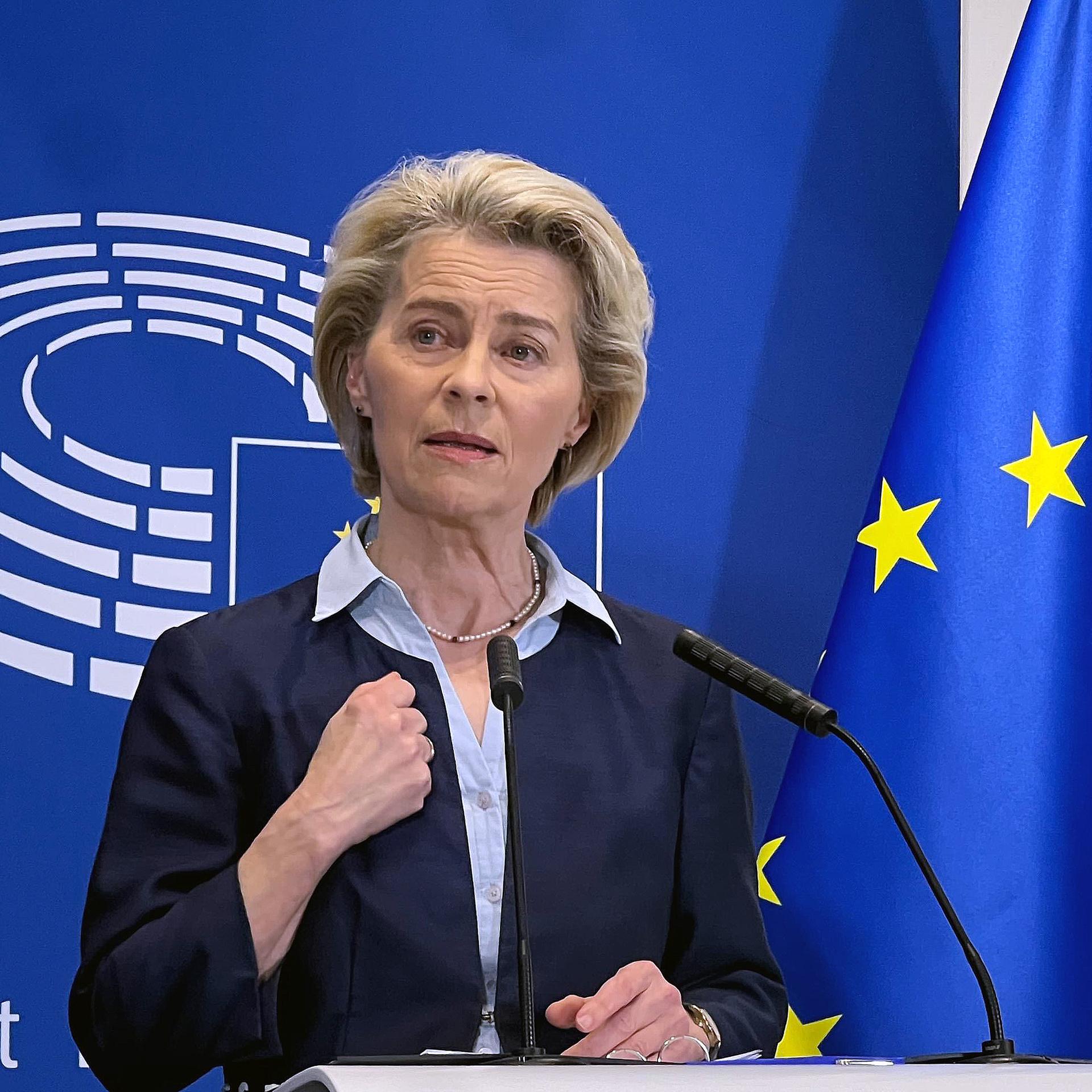 Ursula von der Leyen, Präsidentin der Europäischen Kommission, spricht bei einer Pressekonferenz im Europäischen Parlament. Hinter ihr das Logo des Europäischen Parlaments mit dem stilisierten Plenarsaal und daneben die EU-Flagge.  