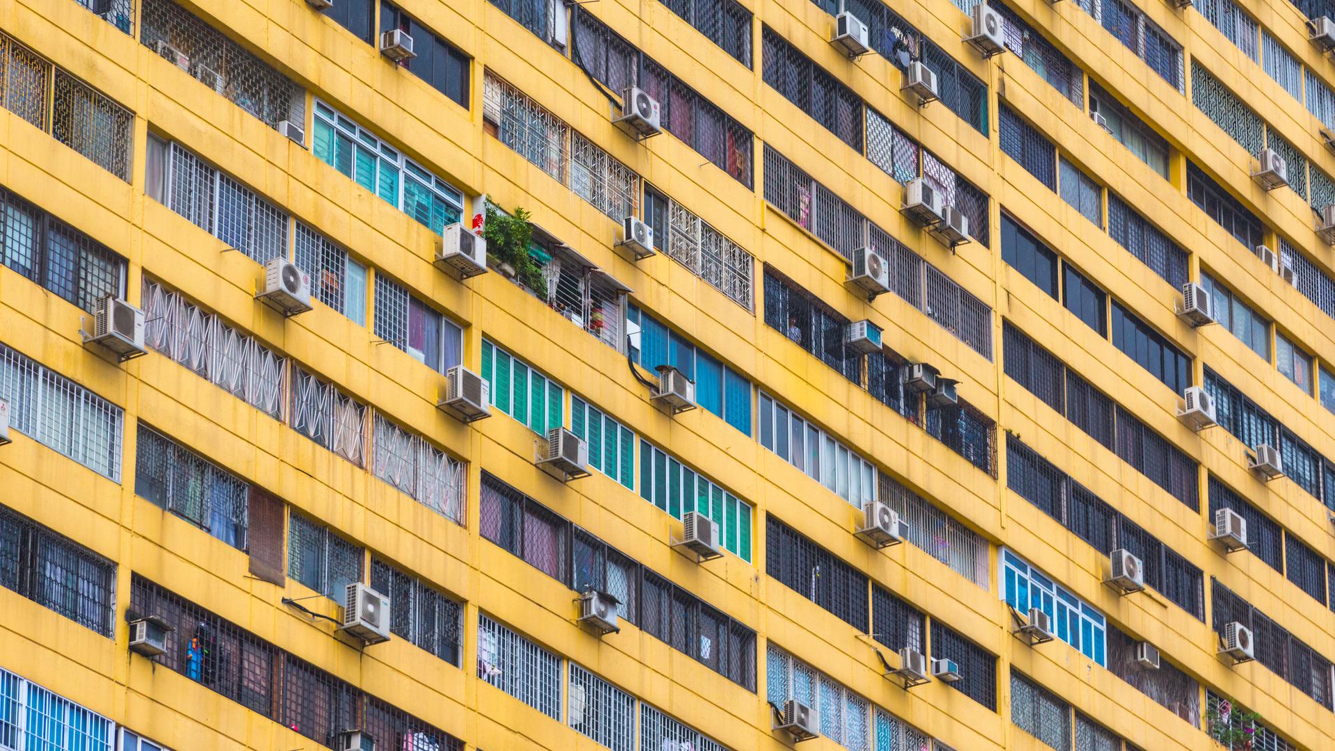 Mehrere Klimaanlagen hängen an der Außenfassade eines Wohngebäcks in Singapur Mehrere Klimaanlagen hängen an der Außenfassade eines Wohngebäcks in Singapur