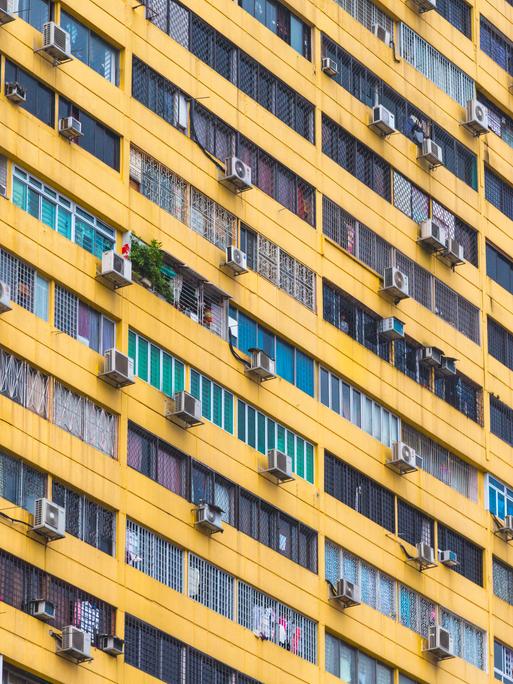Mehrere Klimaanlagen hängen an der Außenfassade eines Wohngebäcks in Singapur Mehrere Klimaanlagen hängen an der Außenfassade eines Wohngebäcks in Singapur