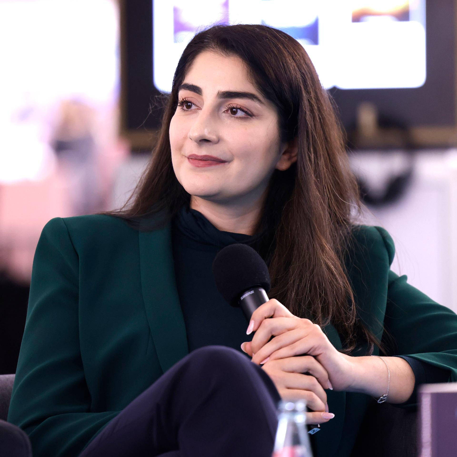 Waslat Hasrat-Nazimi sitzt bei einem Gespräch auf der Frankfurter Buchmesse 2022 mit einem Mikrofon in der Hand in einem Sessel.