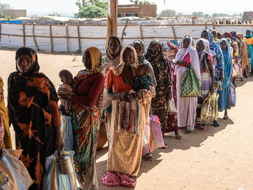 Sudanesische Frauen und Kinder warten in einer Registrierungsstelle in Adre, Tschad, in einer Schlange auf die Verteilung von Hilfsgütern. Sudanesische Frauen und Kinder warten in einer Registrierungsstelle in Adre, Tschad, in einer Schlange auf die Verteilung von Hilfsgütern.