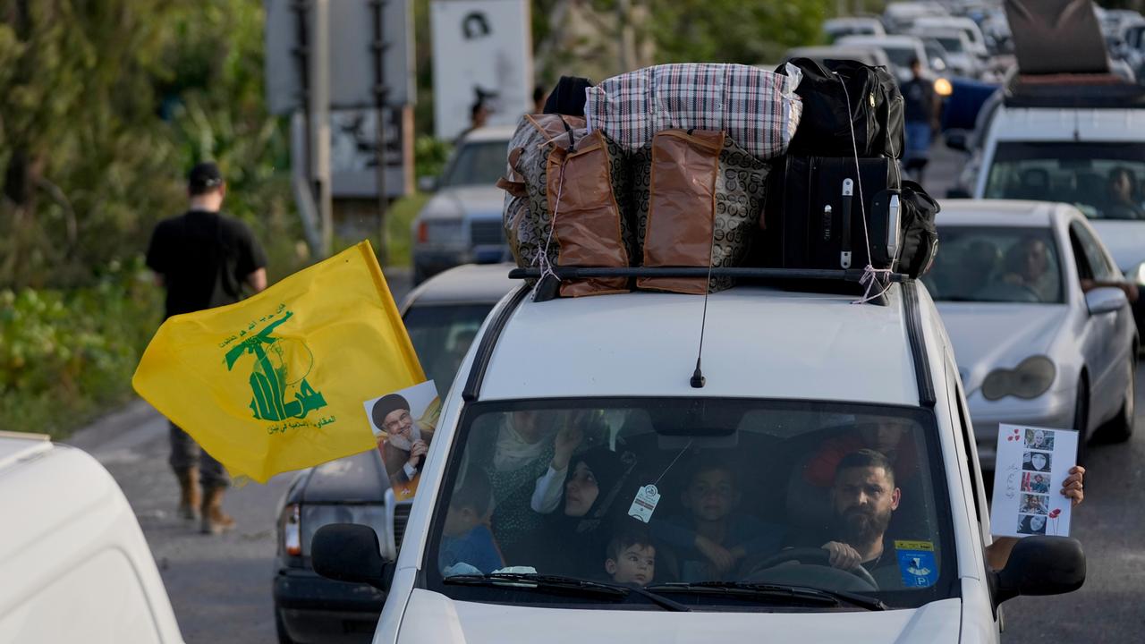 Eine vertriebene Familie fährt in einem Auto mit einer Hisbollah-Flagge und einem Porträt des verstorbenen Hisbollah-Führers Nasrallah Richtung Südlibanon.