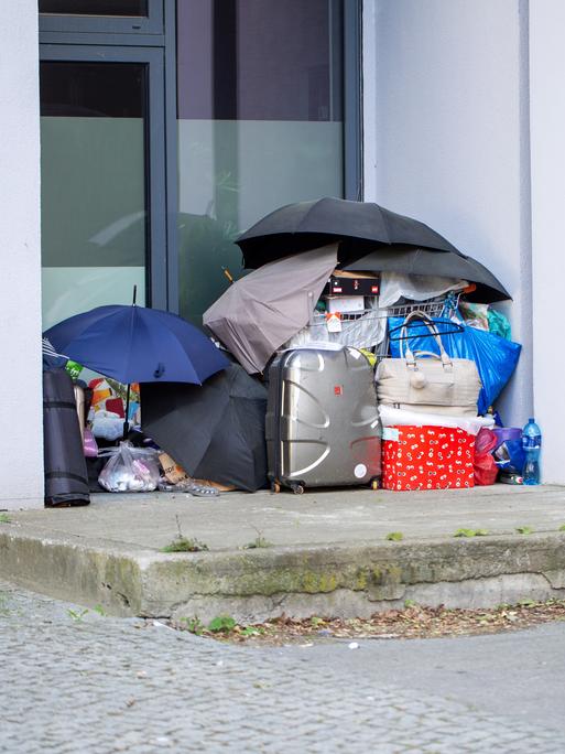 Vor einem Berliner Hauseingang stehen Koffer und Taschen, die unter vier aufgespannten Regenschirmen aufgestapelt sind. Vor einem Berliner Hauseingang stehen Koffer und Taschen, die unter vier aufgespannten Regenschirmen aufgestapelt sind.