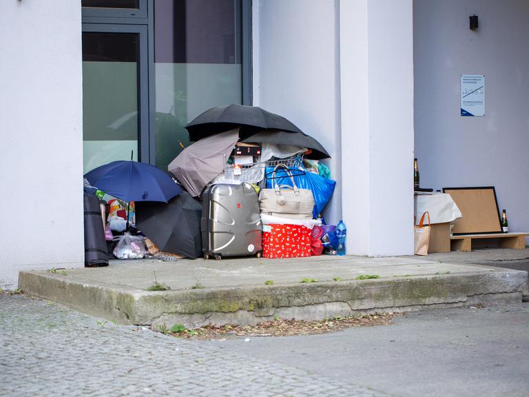 Vor einem Berliner Hauseingang stehen Koffer und Taschen, die unter vier aufgespannten Regenschirmen aufgestapelt sind. Vor einem Berliner Hauseingang stehen Koffer und Taschen, die unter vier aufgespannten Regenschirmen aufgestapelt sind.