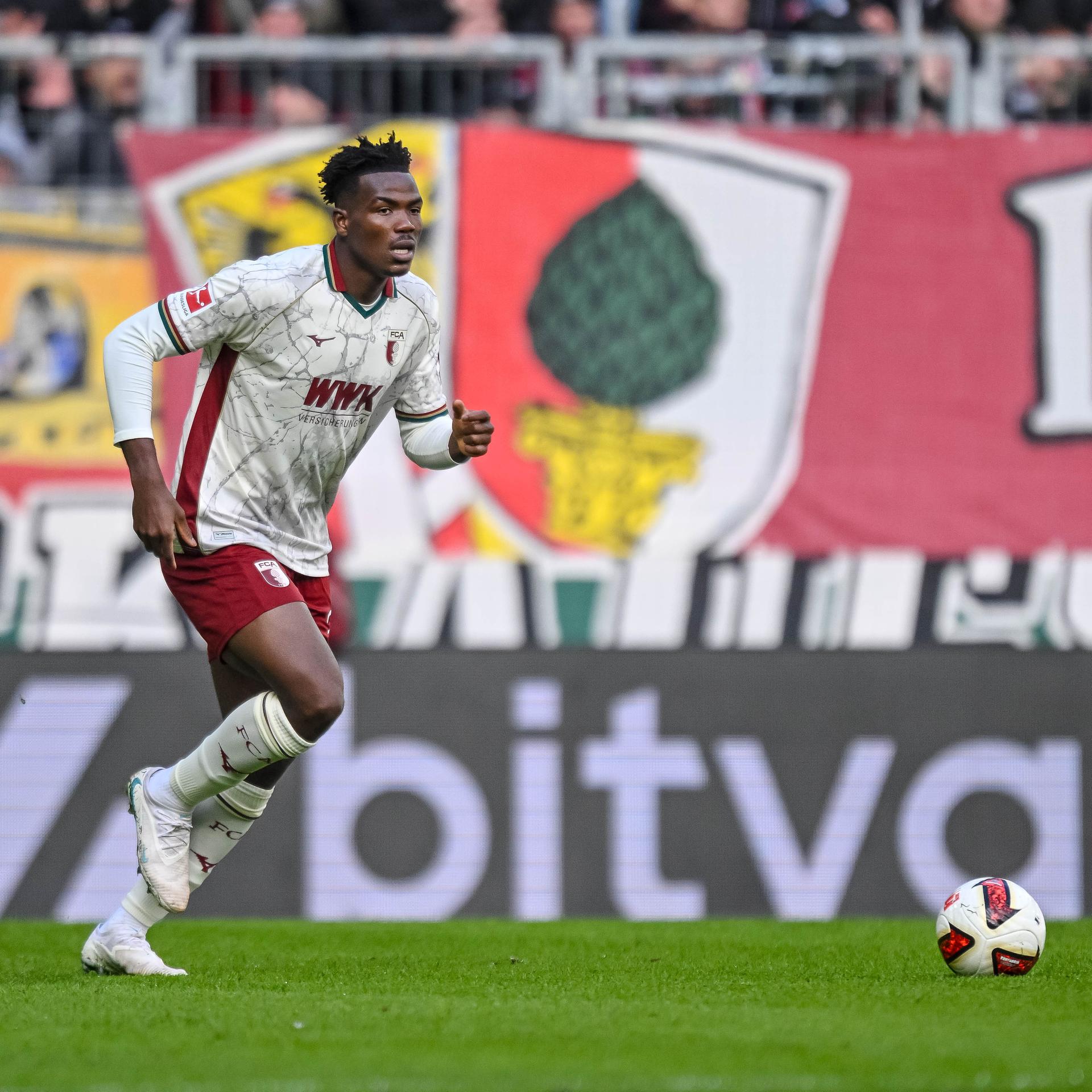 Zu sehen ist der Fußballspieler Juma Bah vom FC Augsburg während eines Bundesligaspiels im Stadion.