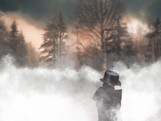 Professor van Dusen: Ein Mann mit unkenntlichem Gesicht im Mantel, der mit seiner Hand an seinen Zylinder fasst. Er steht im Nebel vor einem düsteren winterlichen Wald