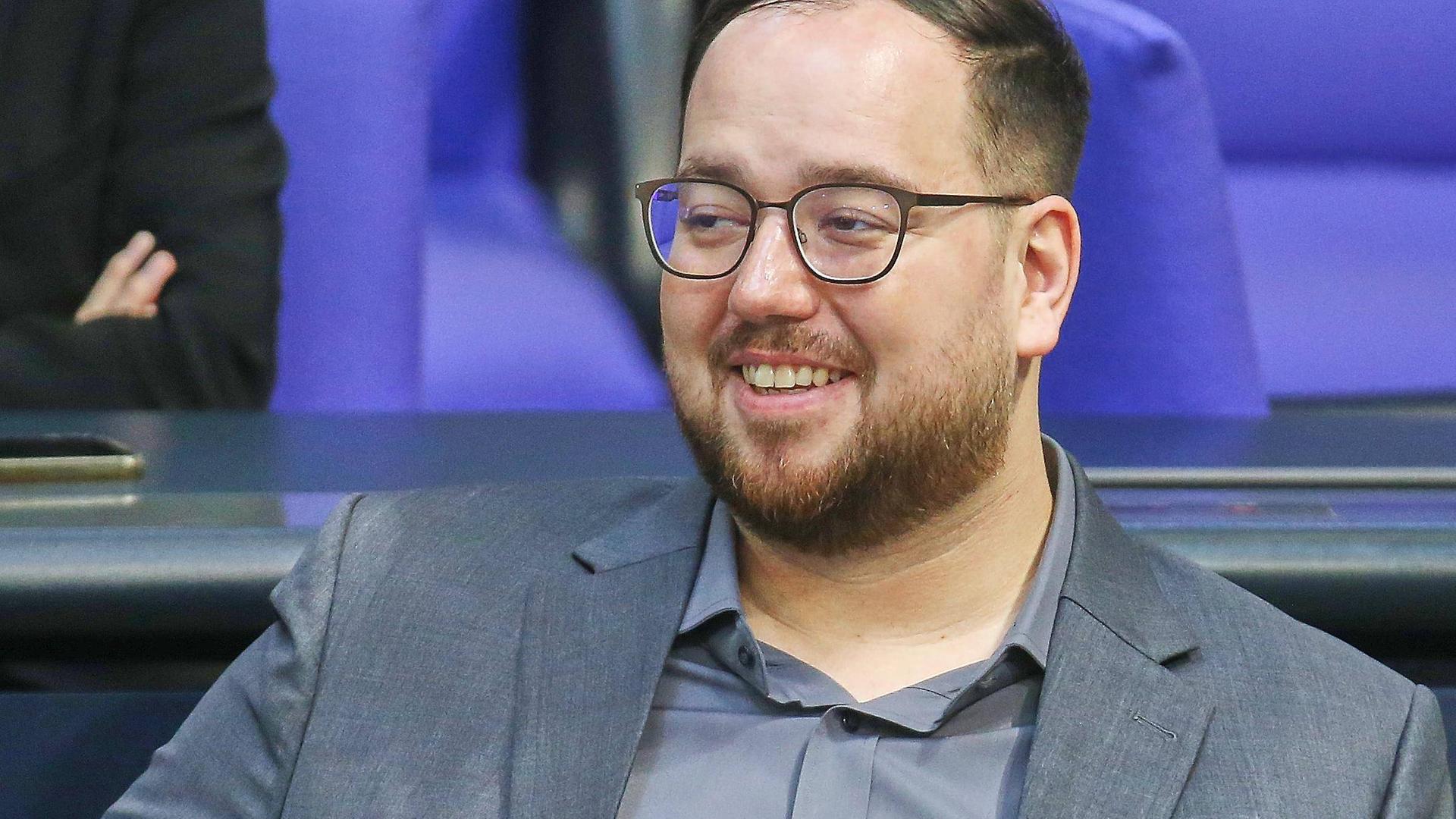 Der AfD-Politiker Carsten Becker sitzt auf einem der blauen Sessel im Plenarsaal des Deutschen Bundestags