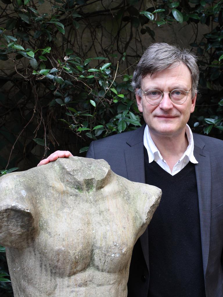 Hans von Trotha steht in einem Garten an eine Statue gelehnt, die einen Männerkörper mit abgeschlagenem Kopf und Gliedmaßen zeigt. Hans von Trotha steht in einem Garten an eine Statue gelehnt, die einen Männerkörper mit abgeschlagenem Kopf und Gliedmaßen zeigt.