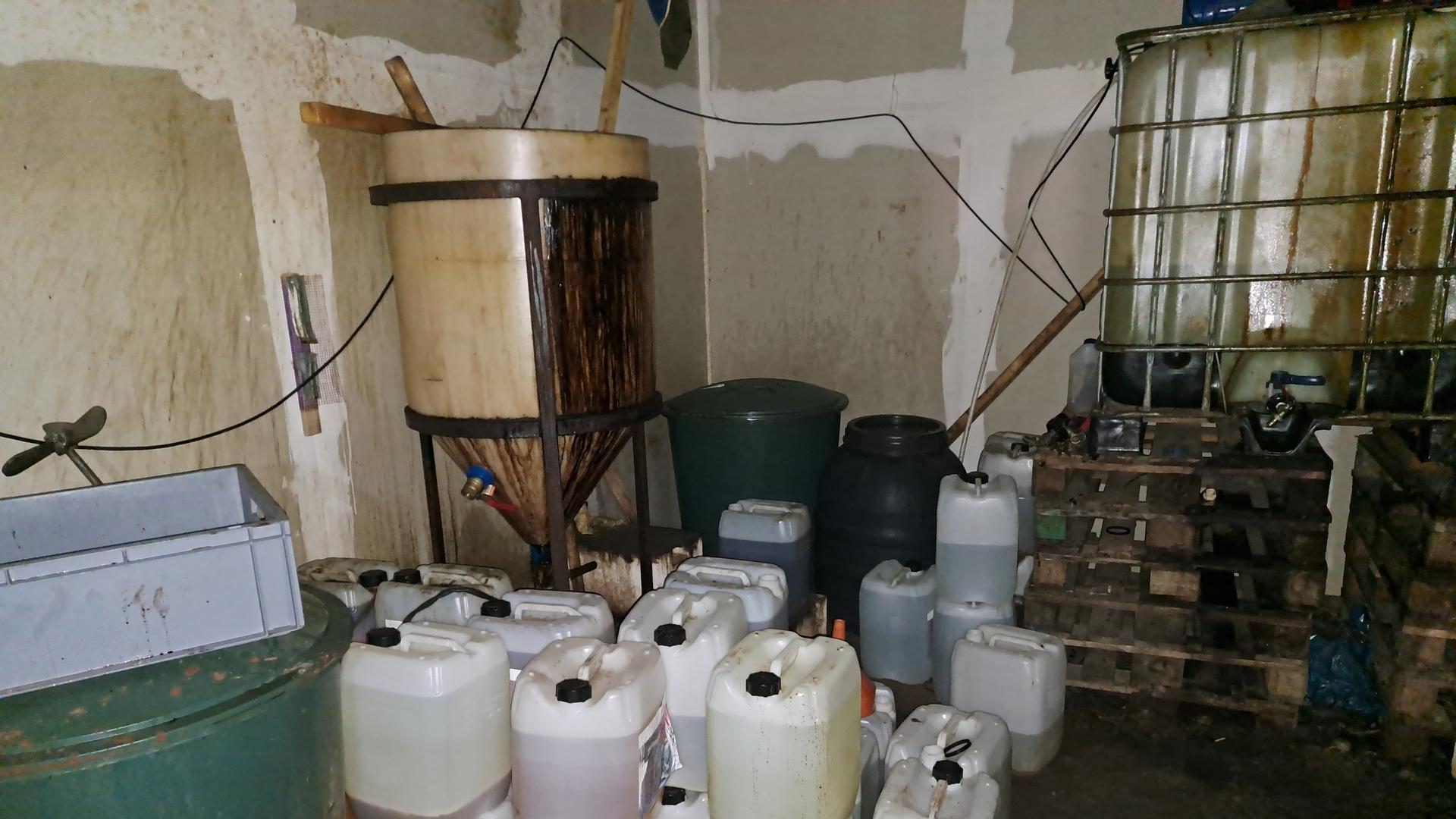Ein großes Drogenlabor in Nauen (Brandenburg) bei Berlin. Im Vordergrund stehen mehrere Plastikkanister, an der hinteren Wand stehen größere Tanks.