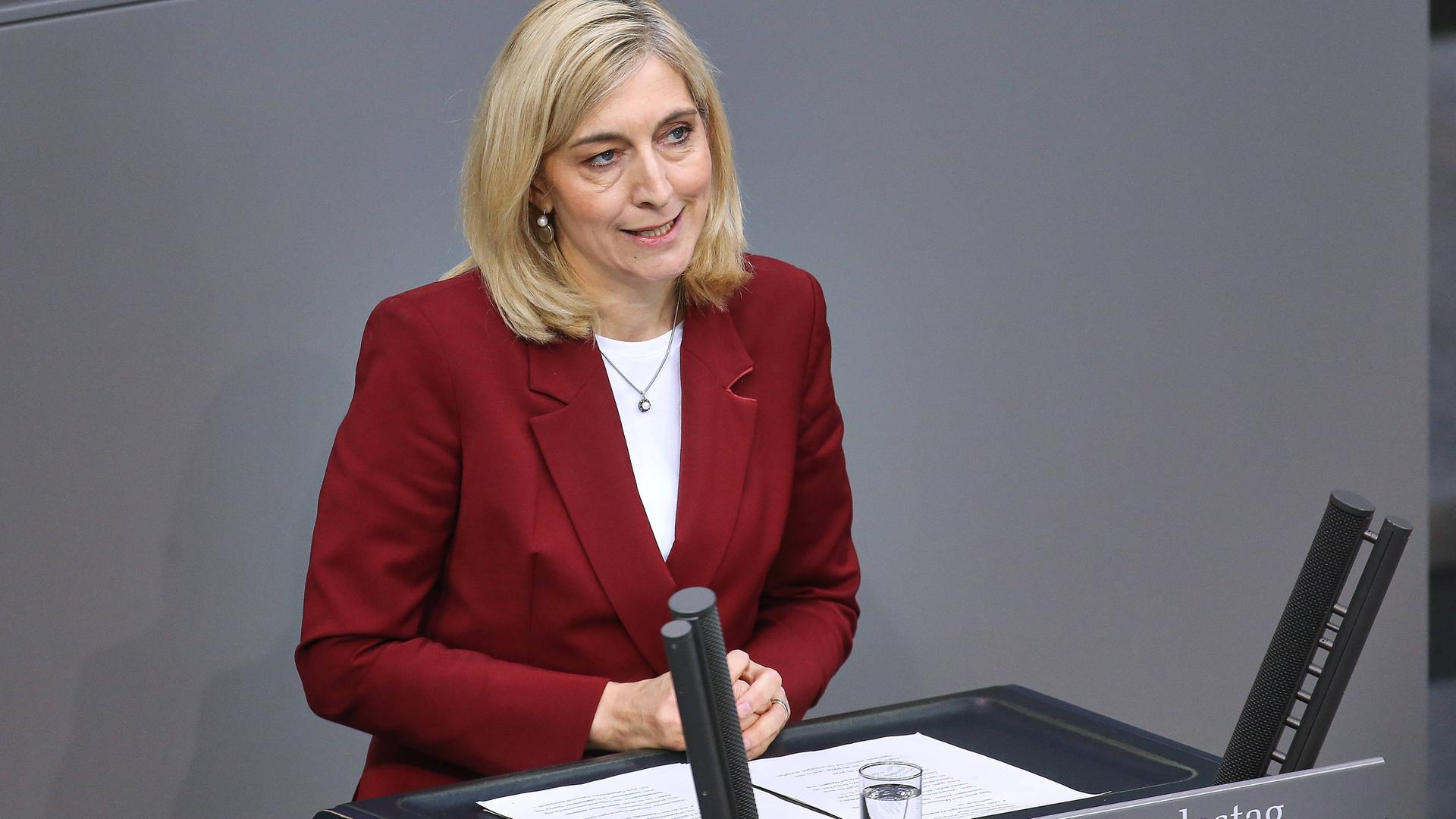 Warken steht am Rednerpult im Bundestag und spricht. Sie hat einen roten Blazer an. Warken steht am Rednerpult im Bundestag und spricht. Sie hat einen roten Blazer an.
