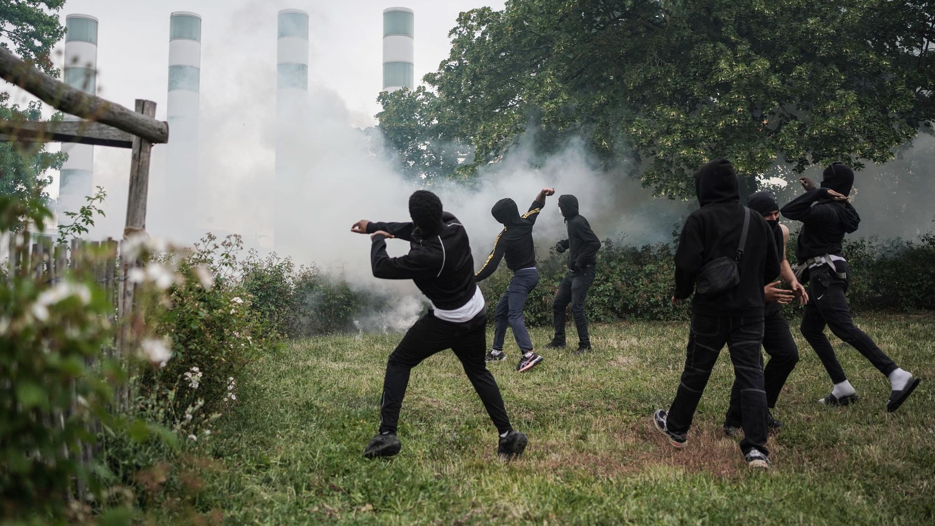 Jugendliche Demonstranten werfen Gegenstände, während sie mit der französischen Polizei zusammenstoßen, am 29. Juni 2023 in Nanterre, Frankreich.