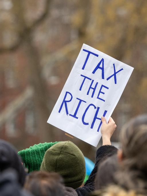 18. Januar 2025, New York, New York, USA: Eine Frau hält ein Schild mit der Aufschrift „Tax the Rich“. Der Volksmarsch in NYC am 18. Januar 2025 war eine bedeutende Demonstration des Widerstands und stimmte mit dem landesweiten Volksmarsch überein. 