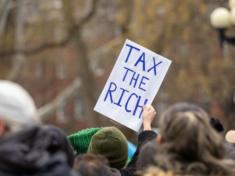 18. Januar 2025, New York, New York, USA: Eine Frau hält ein Schild mit der Aufschrift „Tax the Rich“. Der Volksmarsch in NYC am 18. Januar 2025 war eine bedeutende Demonstration des Widerstands und stimmte mit dem landesweiten Volksmarsch überein. 