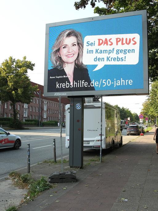 Auf einer digitalen Werbetafel wirbt die Deutsche Krebshilfe mit der Kampagne Sei das Plus im Kampf gegen den Krebs um Spenden. Hoheluft Hamburg