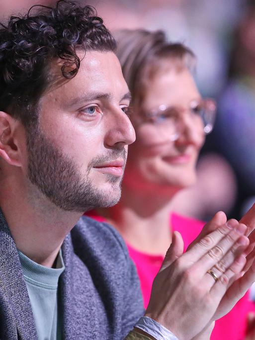 Felix Banaszak und Franziska Brantner sitzen bei der 50. Bundesdelegiertenkonferenz von Bündnis90/Die Grünen in Wiesbaden nebeneinander und klatschen.