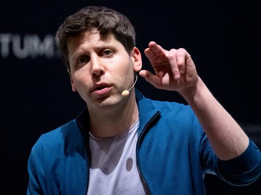 Sam Altman, der Erfinder der KI-Software ChatGPT, mit erhobener Hand bei einer Diskussionrunde.