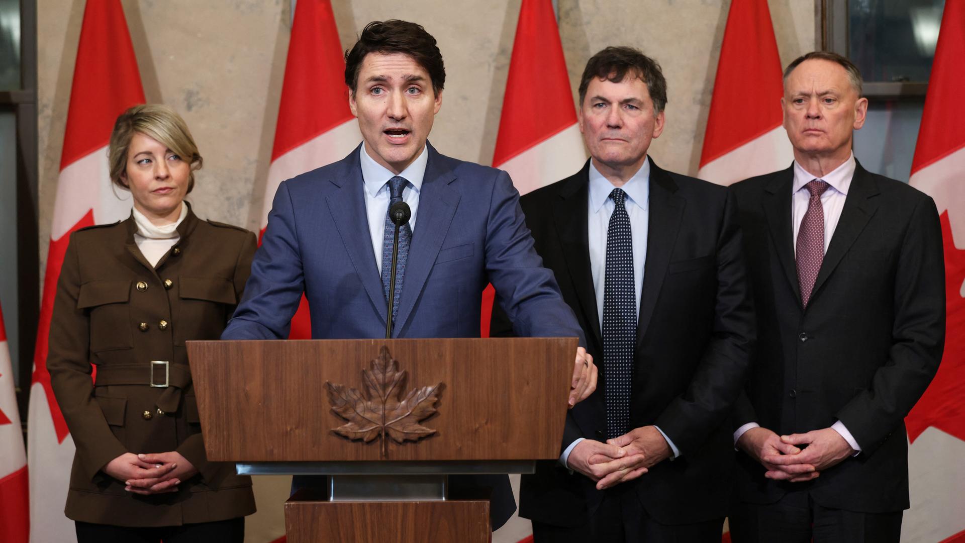 Kanadas Premierminister Justin Trudeau spricht über die US-Zölle gegen Kanada am 4. März 2025 in Ottawa, während Außenministerin Melanie Joly, der Minister für Finanzen Dominic Leblanc und der Minister für öffentliche Sicherheit David McGuinty zusehen.